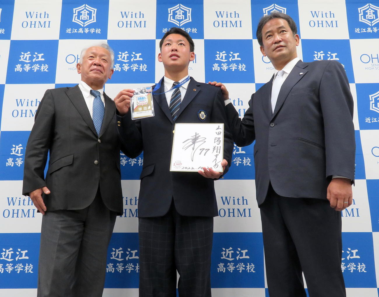 西武ドラフト5位の指名あいさつで潮崎編成グループディレクター（右）から松井監督のサイン色紙などを寄贈されて記念撮影する近江・山田（中央）。左は近江・多賀監督（撮影・鎌田直秀）