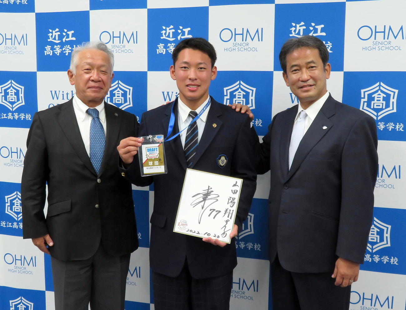 西武ドラフト5位の指名あいさつで潮崎編成グループディレクター（右）から松井監督のサイン色紙などを寄贈されて記念撮影する近江・山田（中央）。左は近江・多賀監督（撮影・鎌田直秀）
