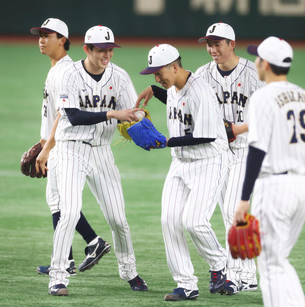 笑顔で球拾いする侍ジャパンの、手前左から佐々木朗、大勢、戸郷（撮影・河田真司）