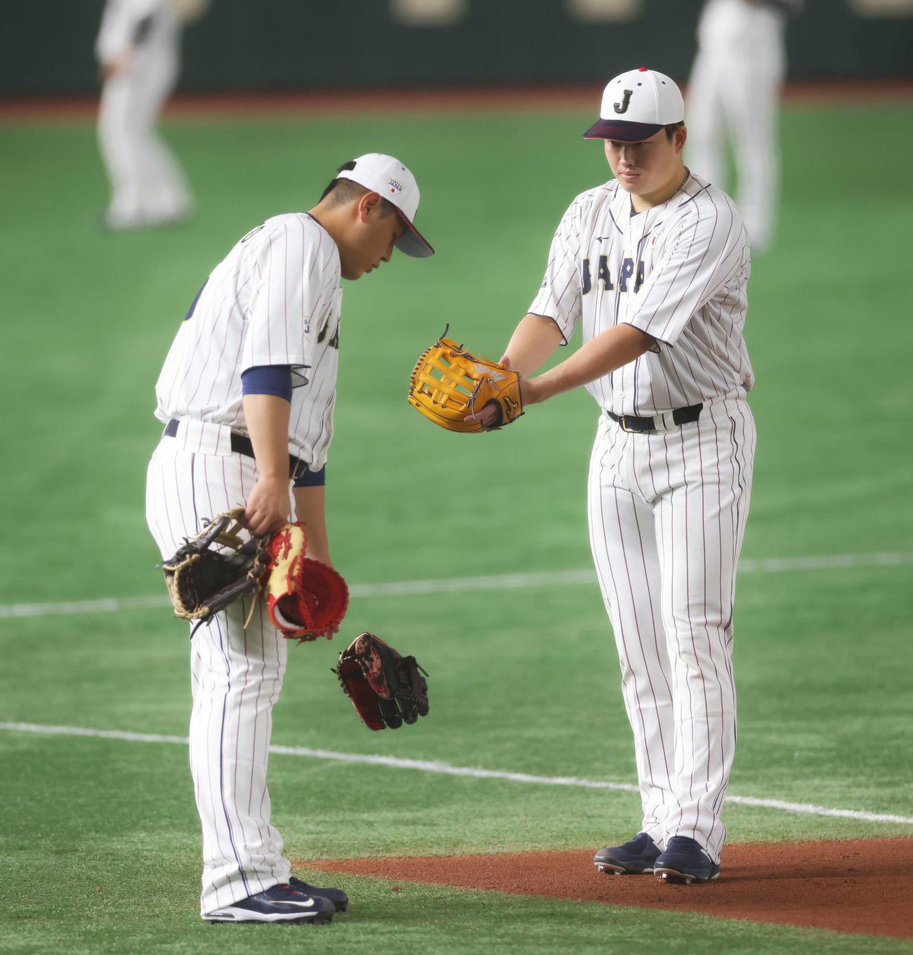 守備位置で言葉を交わす侍ジャパン岡本和（左）と村上（撮影・河田真司）