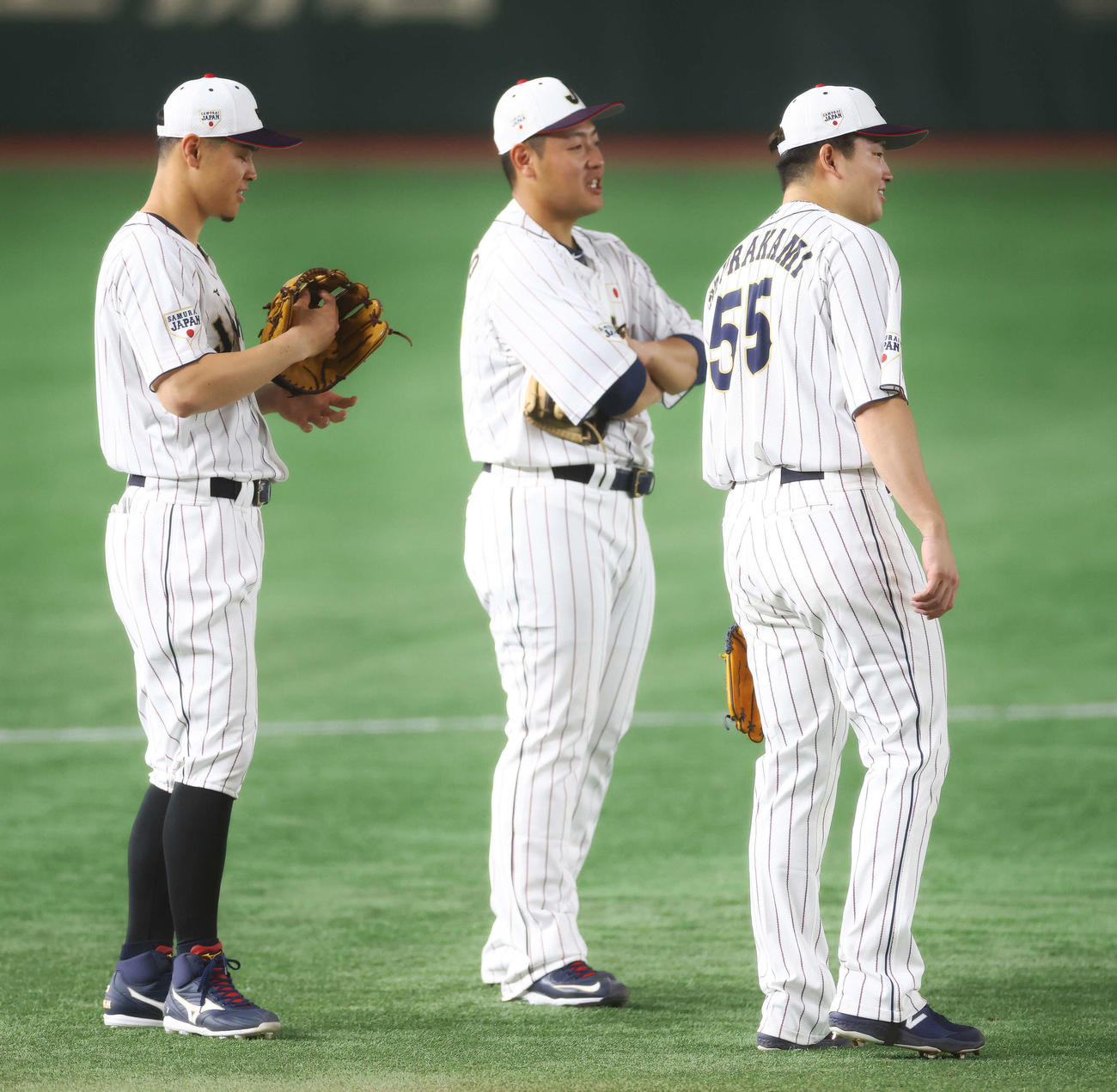 守備位置で言葉を交わす侍ジャパンの、左から佐藤輝、岡本和、村上（撮影・河田真司）