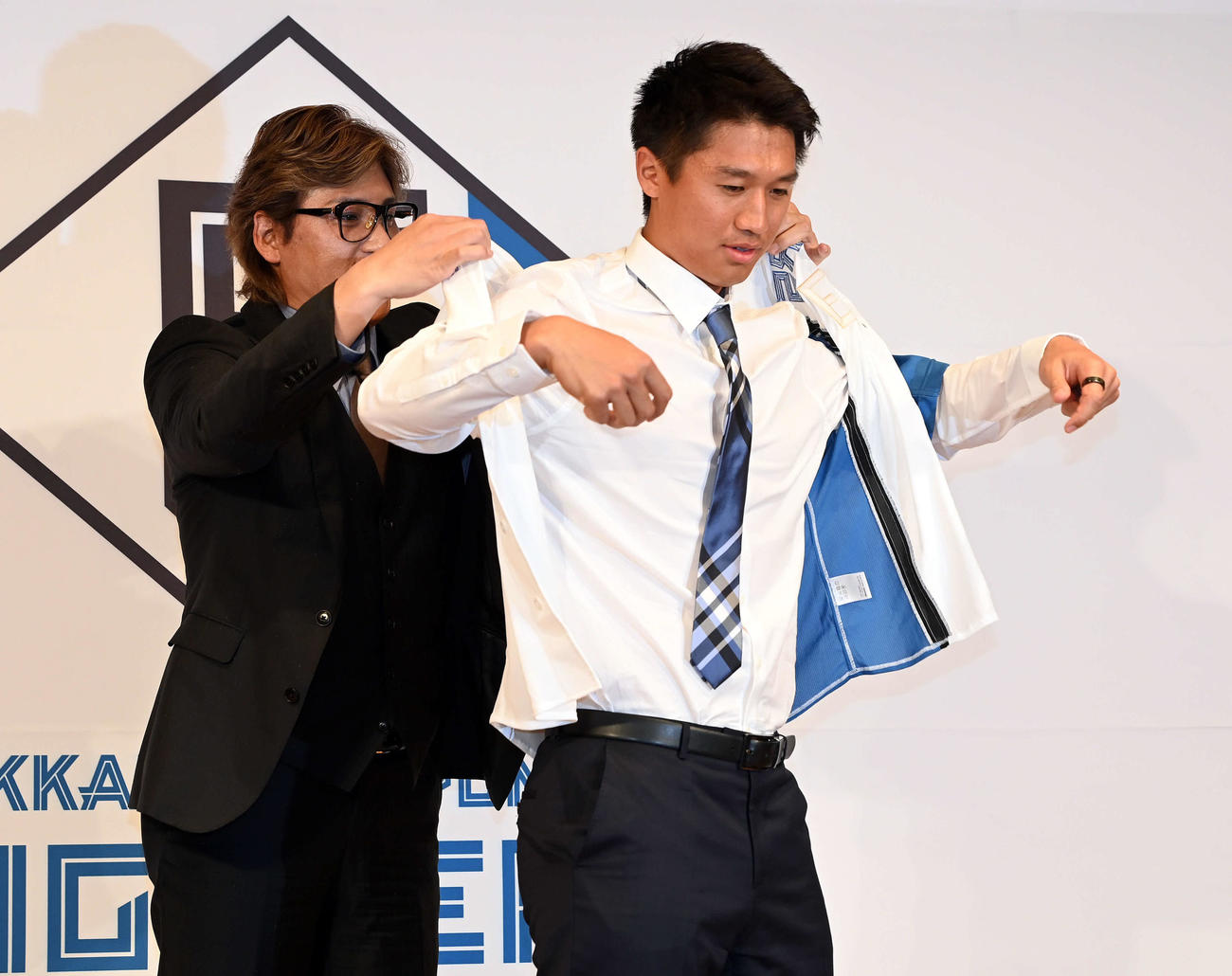 新庄監督にユニホームを着せてもらう日本ハム加藤豪将（撮影・たえ見朱実）