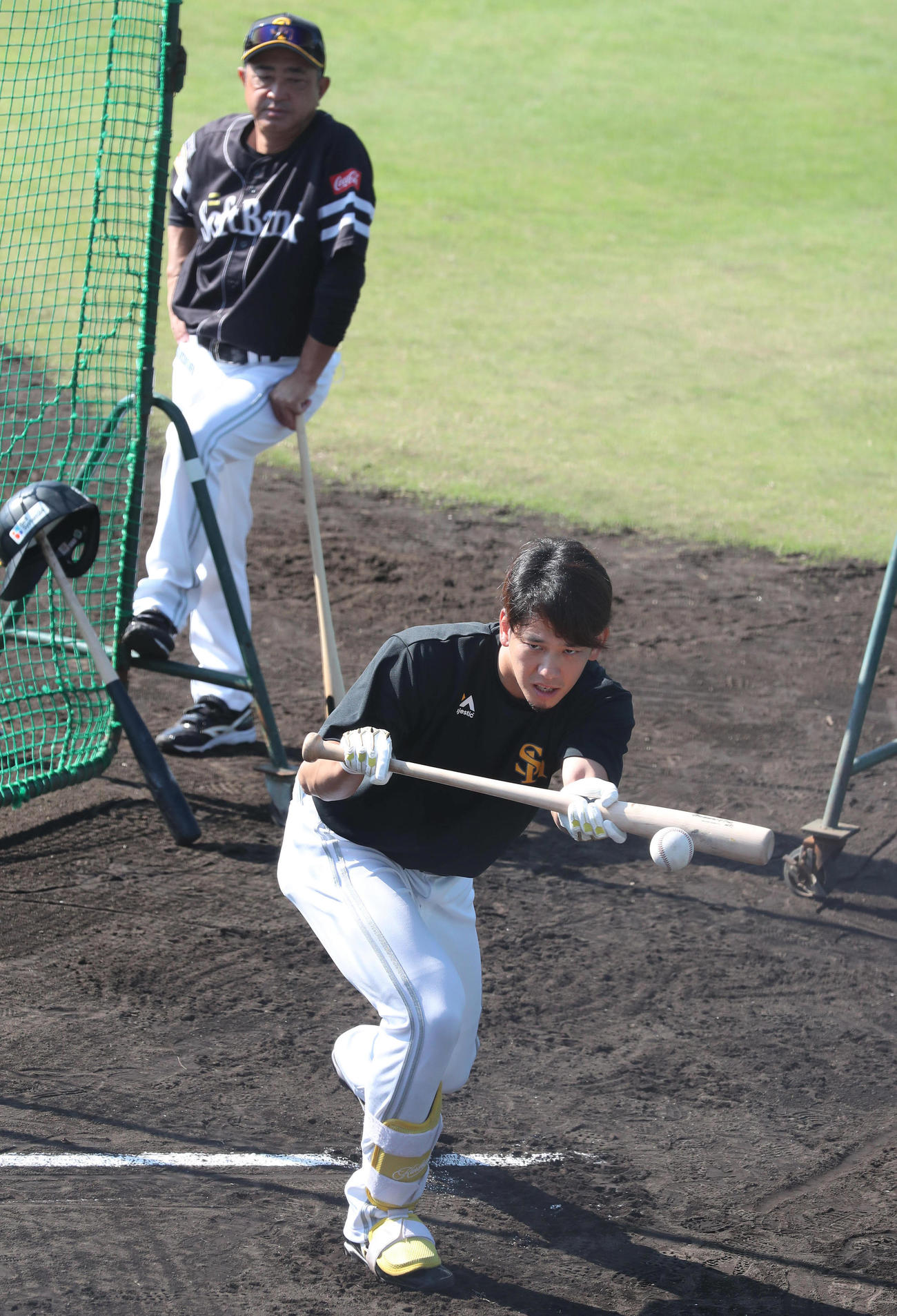 バント練習をする栗原、後方は松山コーチ（撮影・梅根麻紀）
