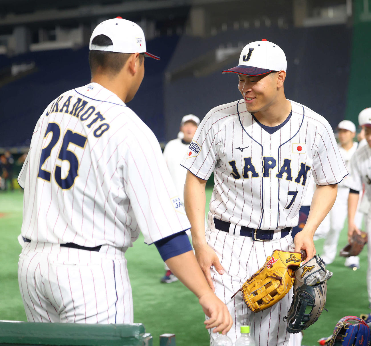 笑顔で言葉を交わす岡本和（左）と佐藤輝（撮影・河田真司）