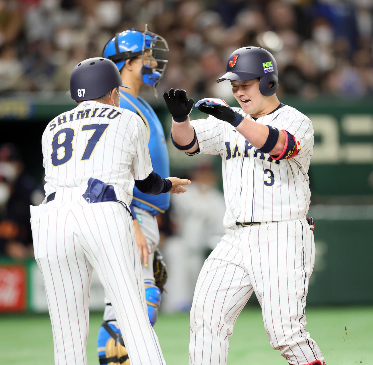 日本代表対日本ハム　1回裏日本代表1死、左中間への本塁打を放ちタッチを交わす牧（右）（撮影・足立雅史）