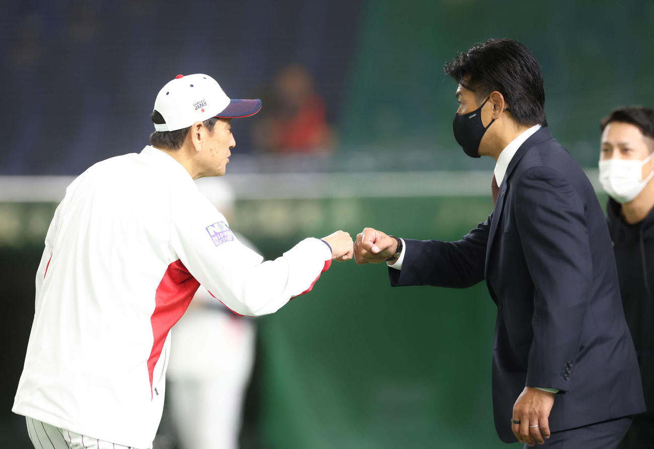 日本代表対日本ハム　試合前、グータッチを交わす栗山監督（左）と日本ハム稲葉GM（撮影・河田真司）