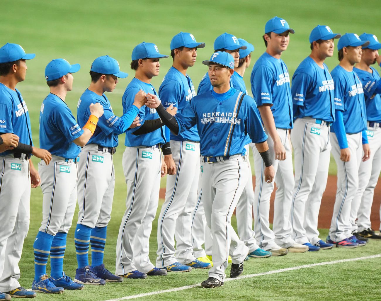 日本代表対日本ハム　試合前のセレモニーでチームメートとタッチを交わす日本ハム江越（中央）（撮影・江口和貴）