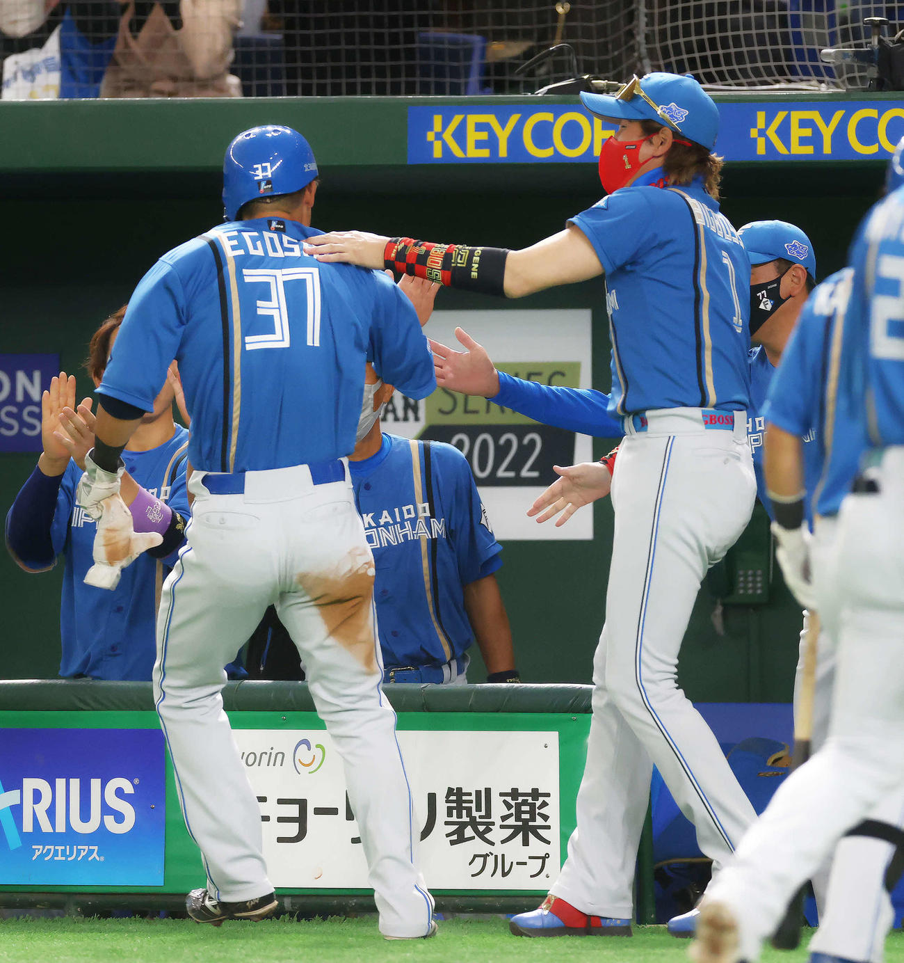 日本代表対日本ハム　4回表日本ハム無死、野村の右飛で生還する江越（左）を迎える新庄監督（撮影・河田真司）