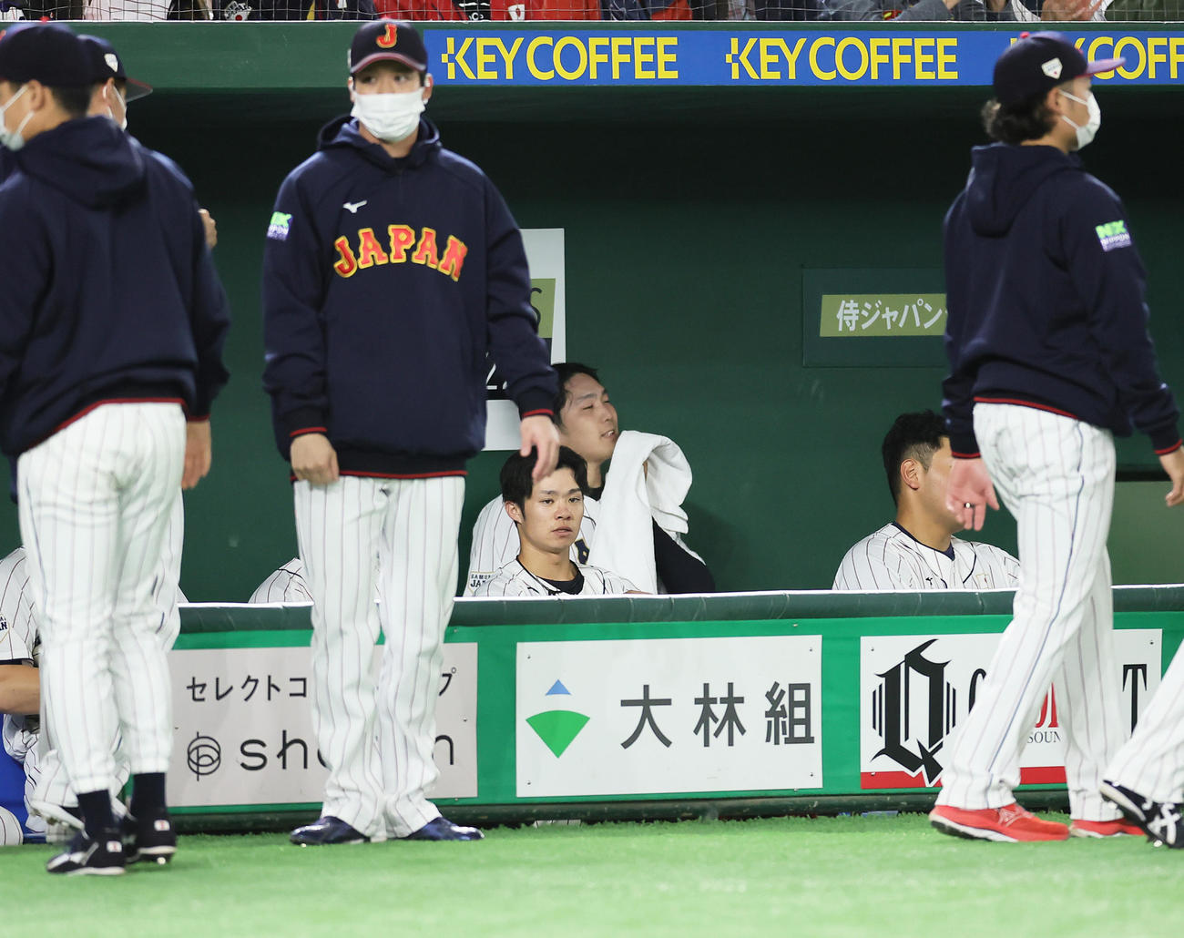 日本代表対日本ハム　4回に3点を失った日本代表石川（後方中央）は厳しい表情でベンチで汗を拭う（撮影・足立雅史）