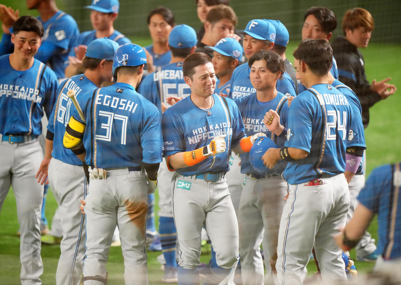 日本代表対日本ハム　7回表日本ハム無死一塁、右飛に倒れ、ベンチ前でチームメートに出迎えられる杉谷（中央）（撮影・江口和貴）