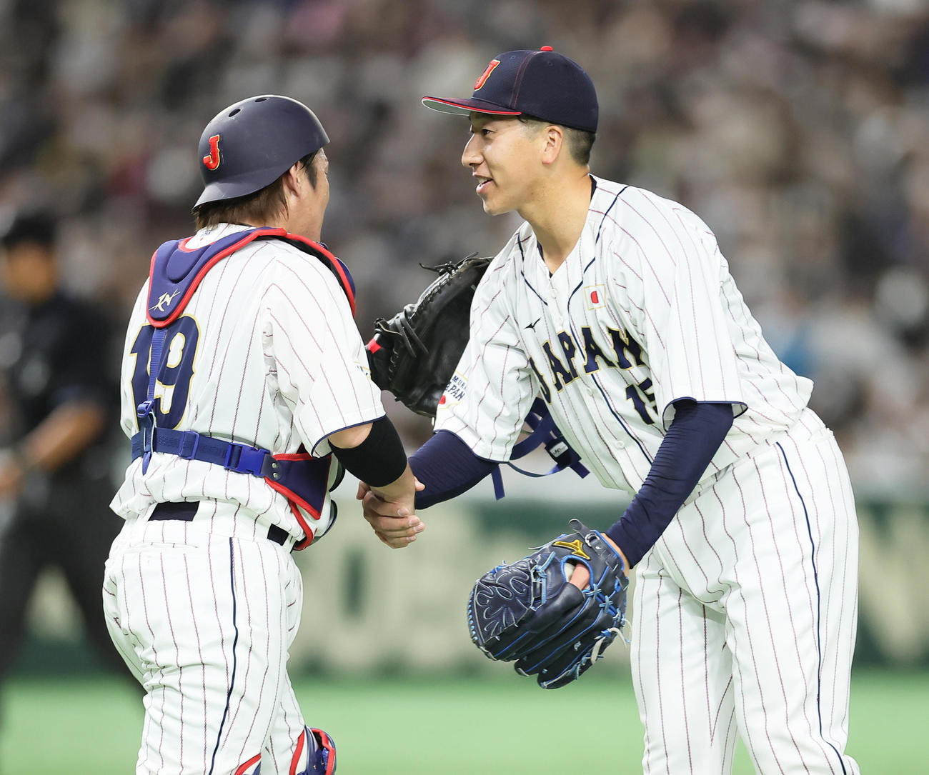 日本代表対日本ハム　9回から登板し無失点で最後を締めた大勢（右）は甲斐と握手を交わす（撮影・足立雅史）