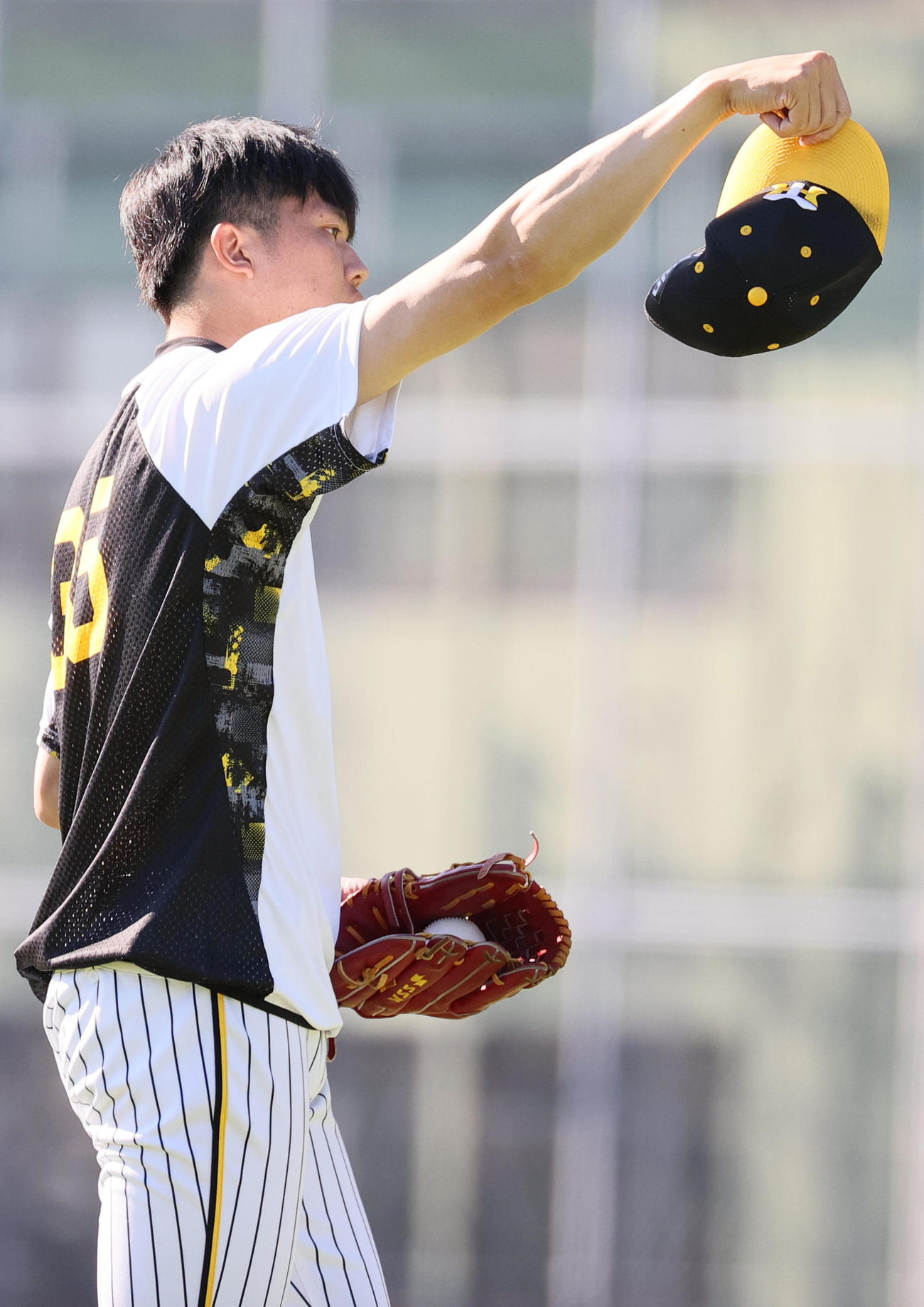 帽子を持った手で腕を振る才木（撮影・上山淳一）