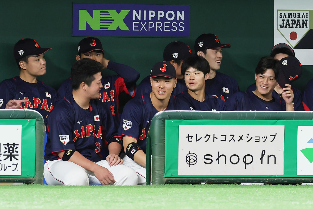 巨人対日本代表　試合前、ベンチで笑顔を見せる日本代表の、前列左から牧、佐藤輝ら（撮影・足立雅史）