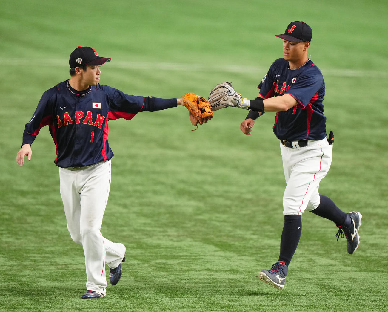 巨人対日本代表　4回裏終了後、日本代表二塁手山田（左）とタッチを交わしながらベンチに引き揚げる右翼手の佐藤輝（撮影・江口和貴）