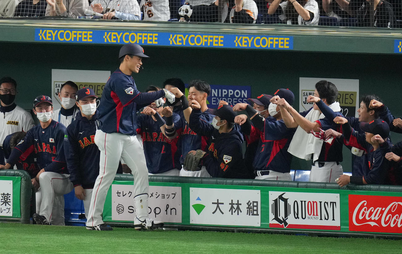 巨人対日本代表　9回表日本代表無死、ソロ本塁打を放った塩見（左）はナインの出迎えを受ける（撮影・垰建太）