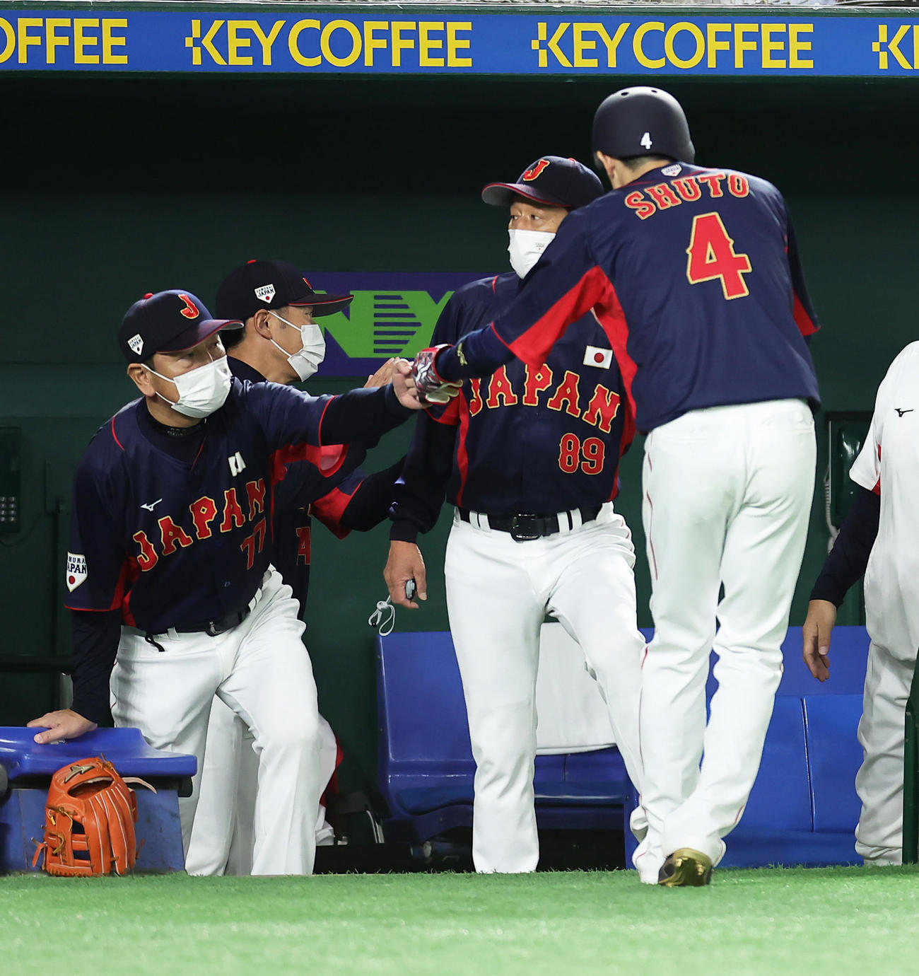 巨人対日本代表　タイブレーク練習の日本代表無死二塁、西川の適時打で生還した周東（右端）を迎える栗山監督（右から2人目）ら（撮影・足立雅史）