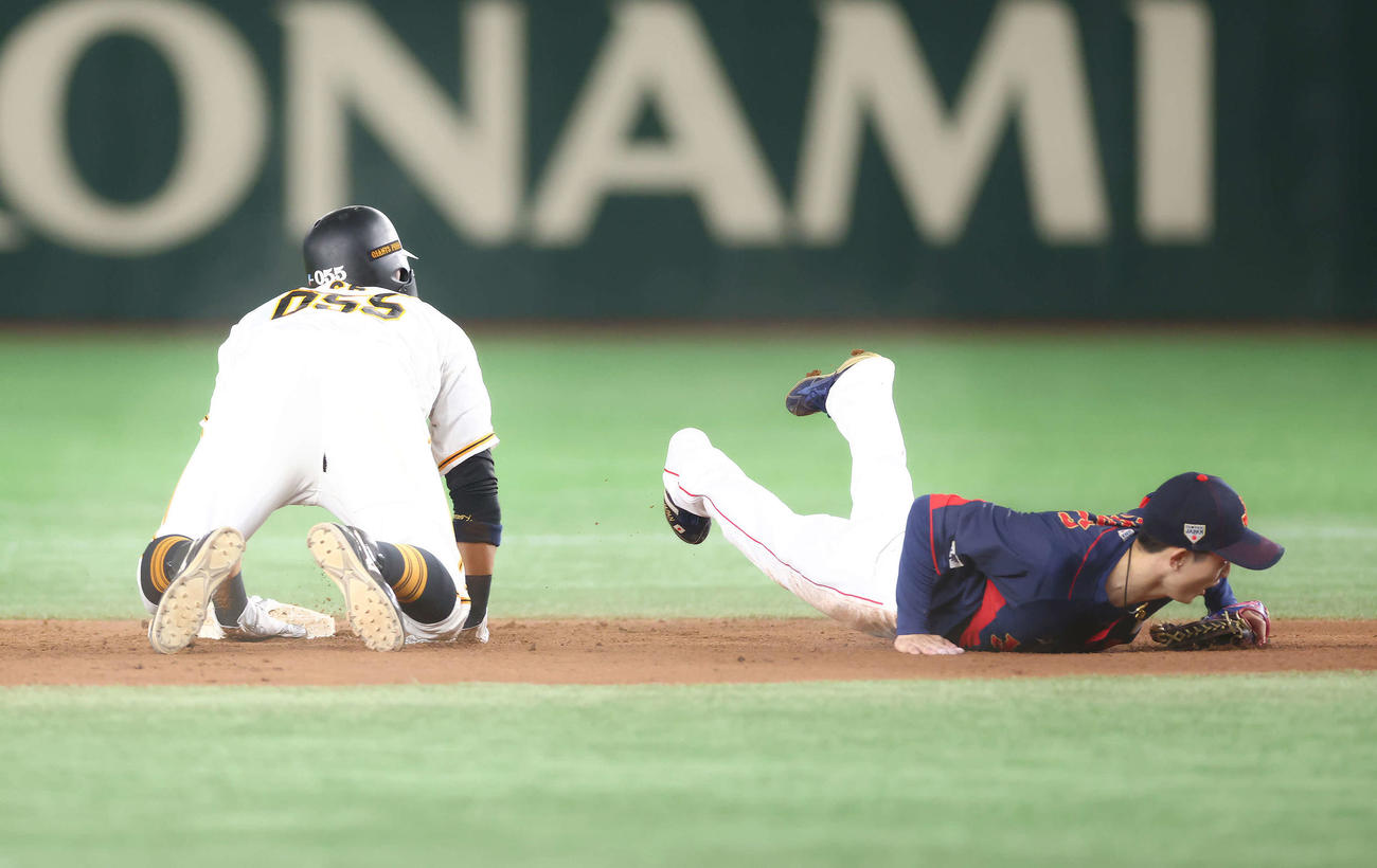 巨人対日本代表　試合後タイブレーク戦で村上の送球する球を捕球できず倒れる周東（撮影・河田真司）