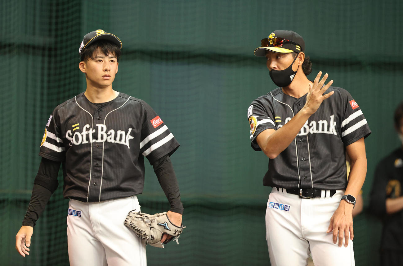 ブルペンでの投げ込みを終えた板東（左）は斉藤コーチと話し合う（撮影・梅根麻紀）