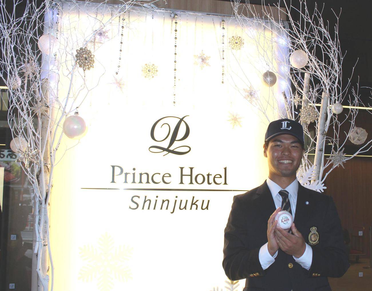 入団に合意し、クリスマス仕様のプリンスホテル新宿のエントランスで笑顔を見せる西武育成4位の法大・是沢（撮影・保坂恭子）
