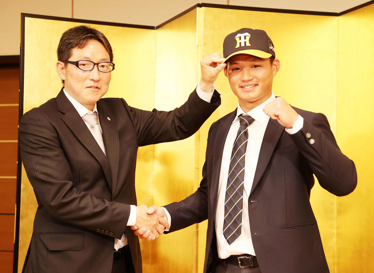 阪神と仮契約した中大・森下（右）は吉野スカウトと握手（撮影・鈴木正人）