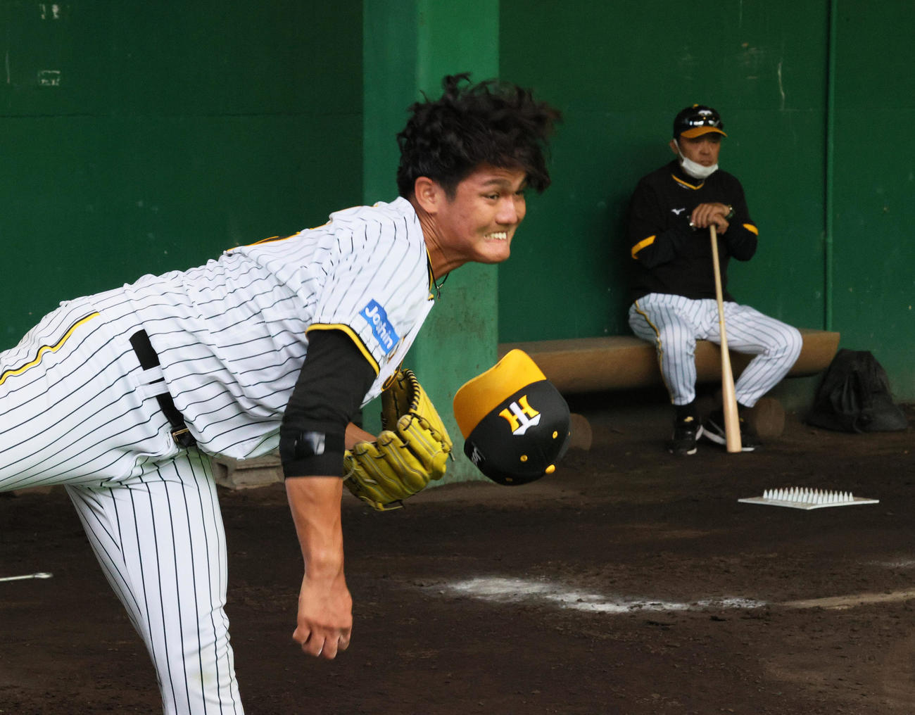ブルペンで投げ込む西純（左）をチェックする岡田監督（撮影・上山淳一）
