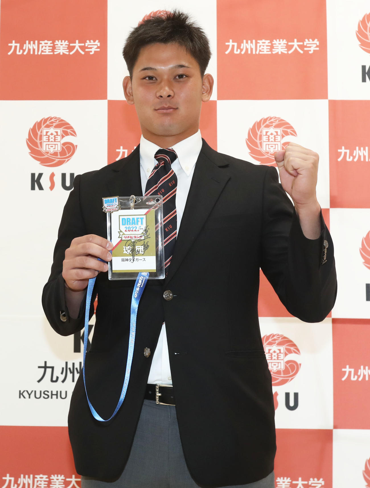 ドラフト会議のパスを手にガッツポーズをする育成ドラフト1位の九産大・野口（撮影・屋方直哉）