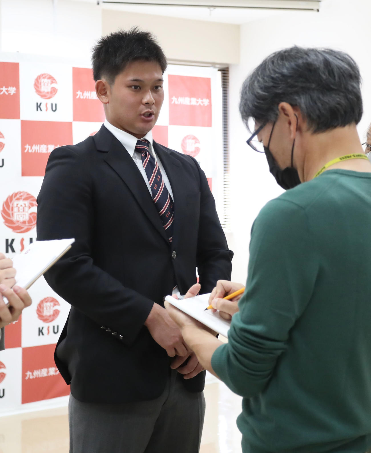 囲み取材を受ける育成ドラフト1位の九産大・野口（撮影・屋方直哉）