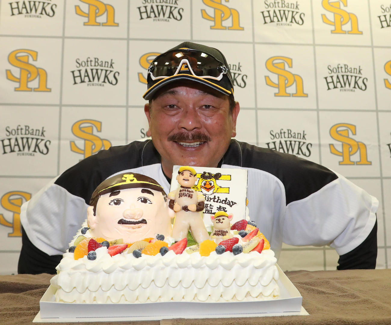 59歳の誕生日を迎えた藤本博史監督はケーキの前で笑顔（撮影・梅根麻紀）