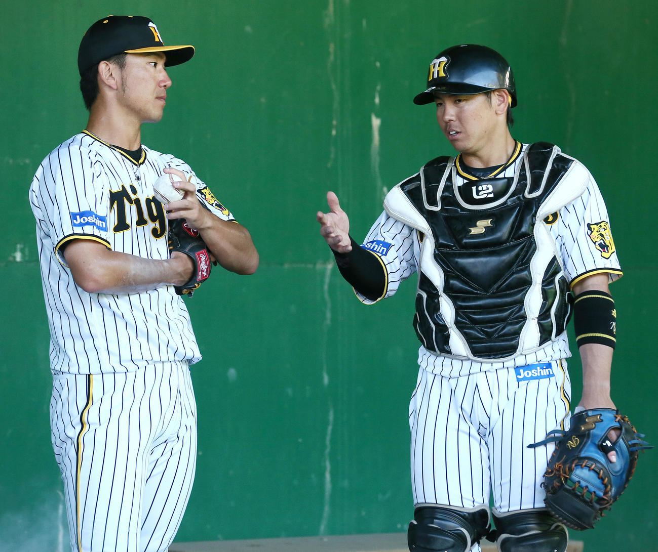 ブルペンで投球を終えた伊藤将（左）にアドバイスする梅野（撮影・上山淳一）