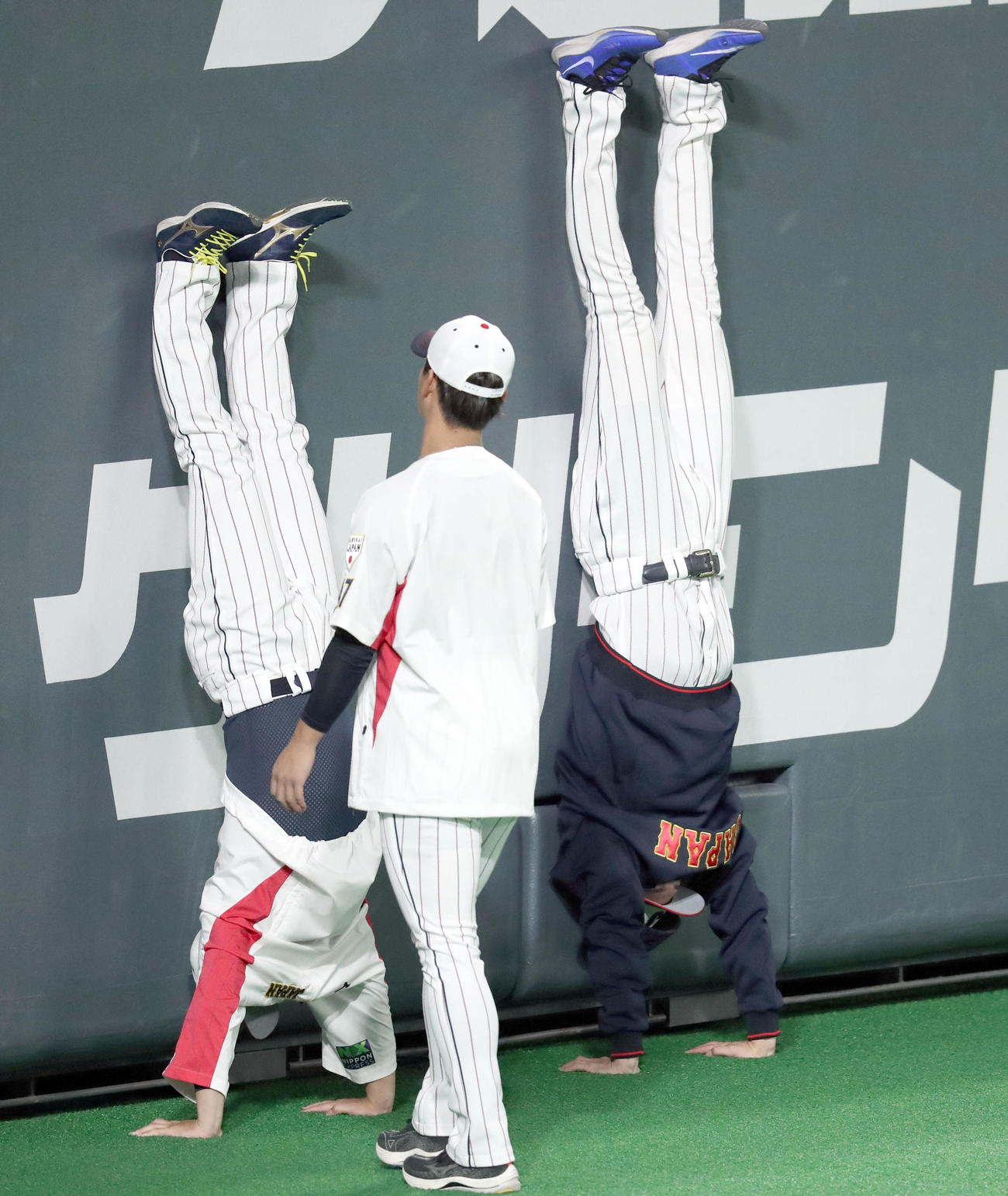 壁を使って逆立ちをする侍ジャパン宮城（左）と佐々木朗（撮影・佐藤翔太）