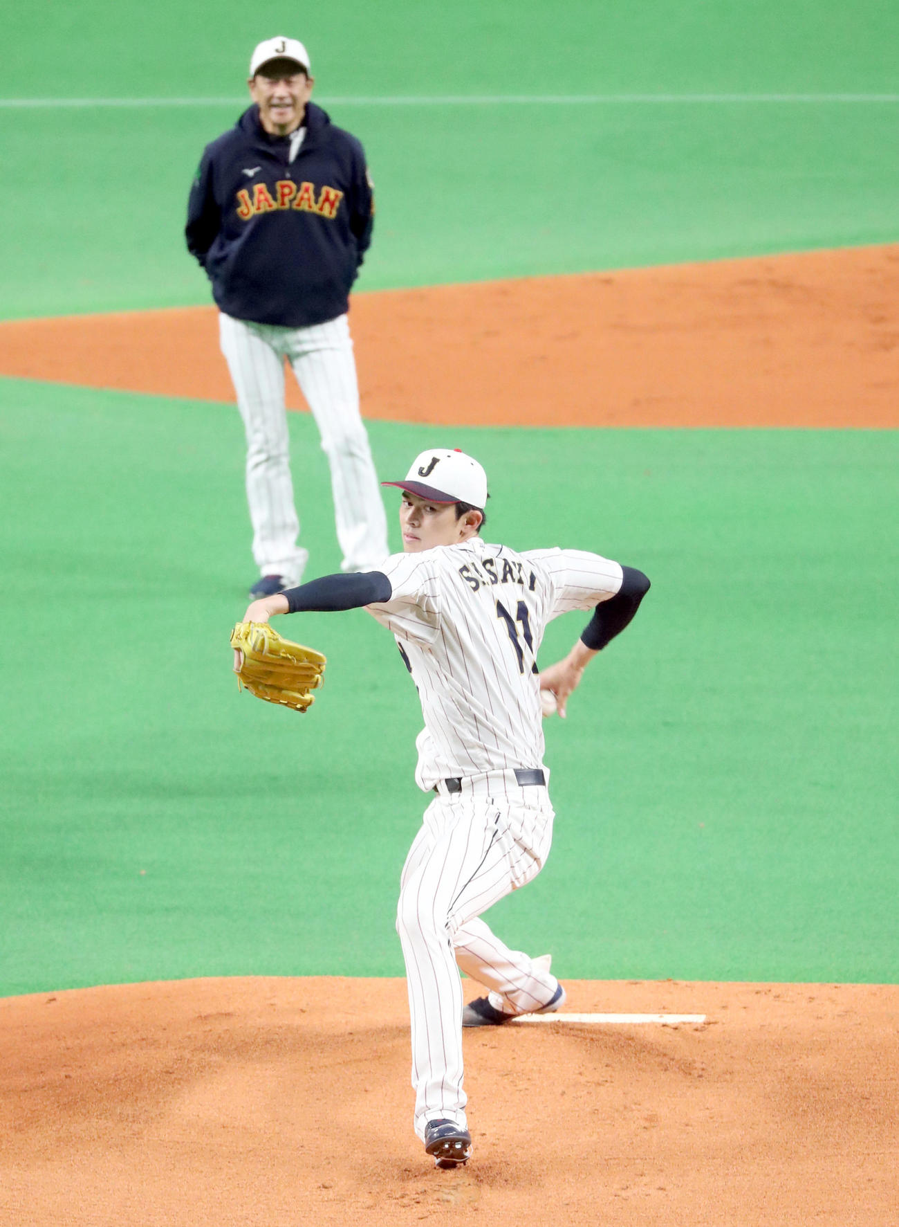 侍ジャパン栗山監督（左後方）が見つめる中、投球練習をする佐々木朗（撮影・佐藤翔太）