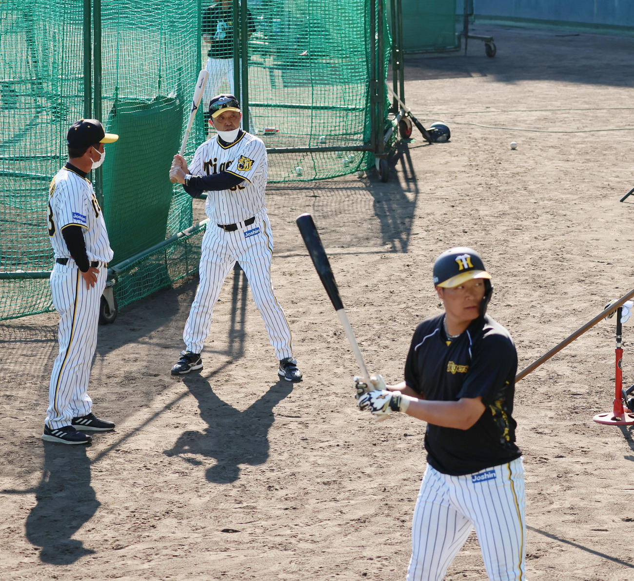 大山（右）のティー打撃を見て水口コーチ（左）にアドバイスを伝える岡田監督（撮影・加藤哉）
