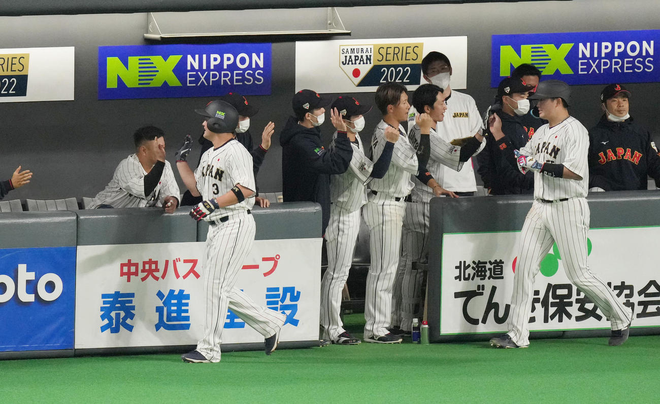 日本対オーストラリア　2回裏日本1死二、三塁、岡本和の2点適時打で生還し、ナインに迎えられる三塁走者村上（右から2人目）と二塁走者牧（左から2人目）（撮影・菅敏）