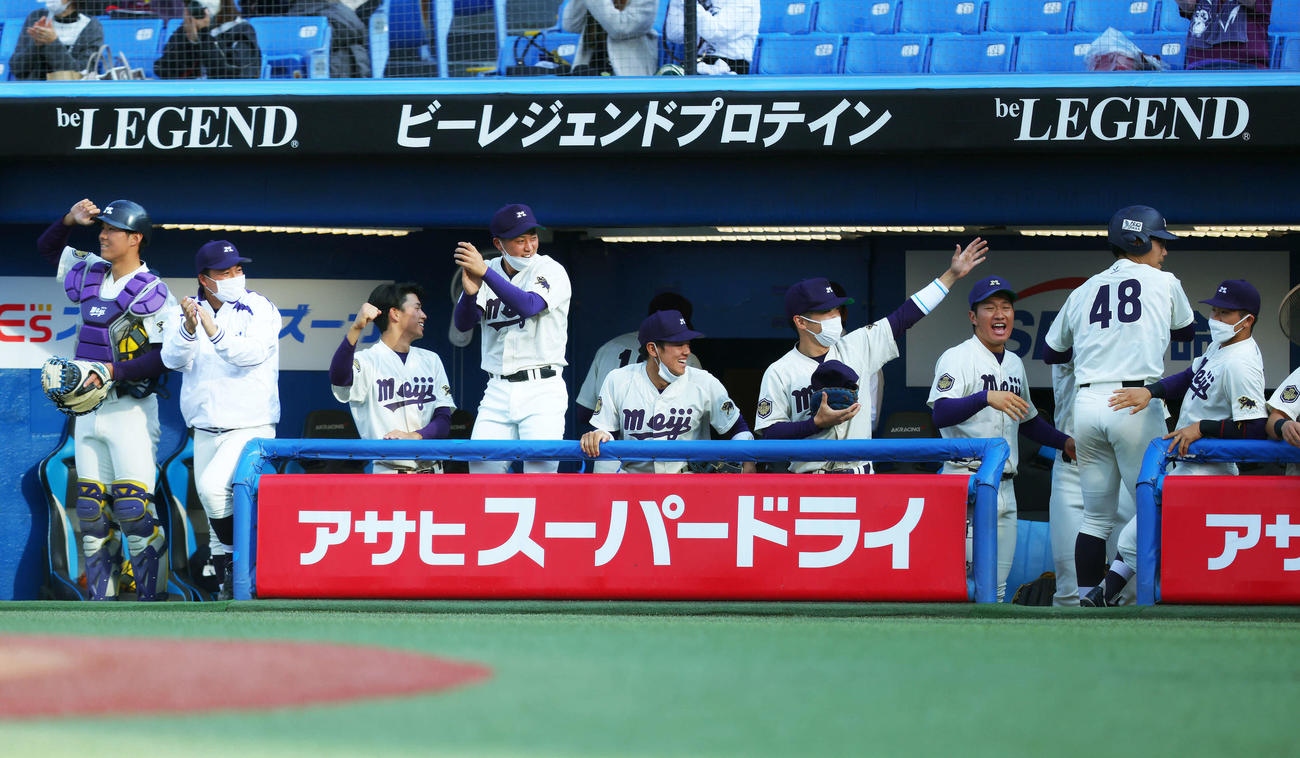 東大対明大　東大対明大　4回裏明大2死一、二塁、中山の2点適時二塁打で生還し、ベンチナインに迎えられる明大・瀬（右から2人目）（撮影・河田真司）