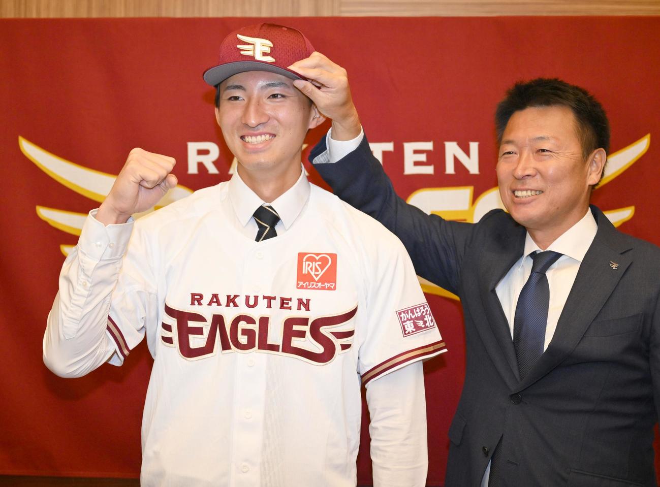 沖原佳典スカウト（右）から帽子をかぶせてもらうドラフト1位の立大・荘司康誠（代表撮影）