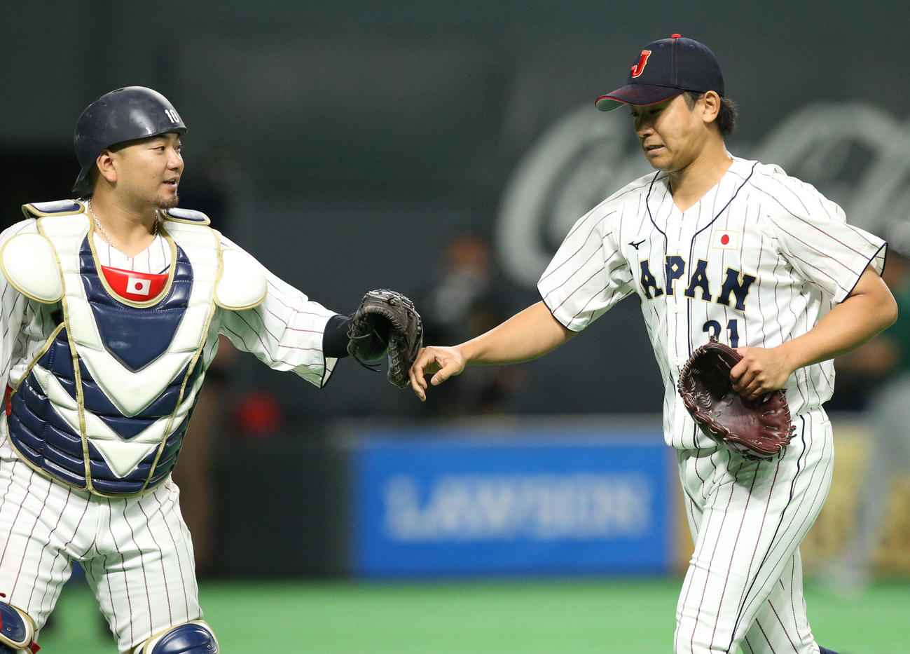 日本対オーストラリア　3回表を無失点に抑えタッチを交わしながらベンチに戻る森（左）と今永（撮影・佐藤翔太）