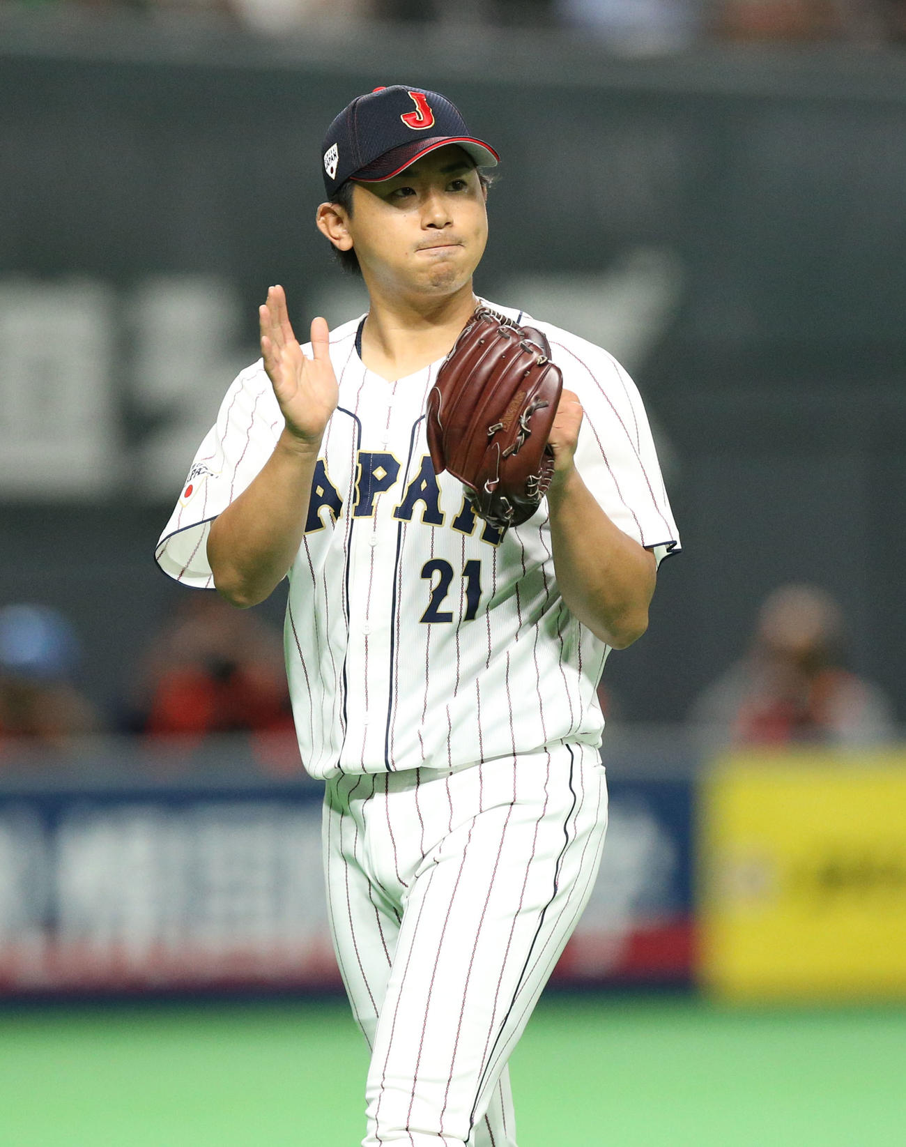 日本対オーストラリア　4回表を無失点に抑えグラブたたきながらベンチに戻る今永（撮影・佐藤翔太）