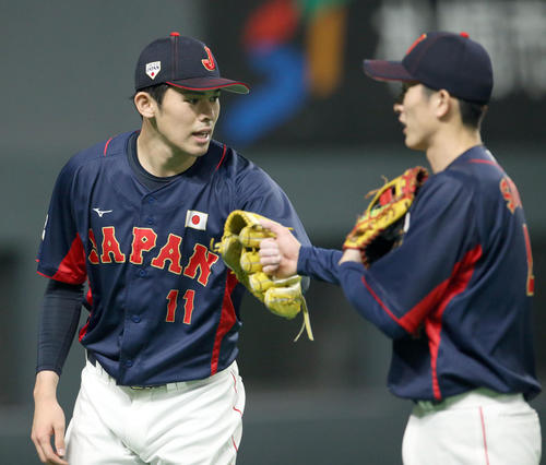 オーストラリア対日本　佐々木朗（左）は周東を出迎えながらベンチに戻る（撮影・佐藤翔太）
