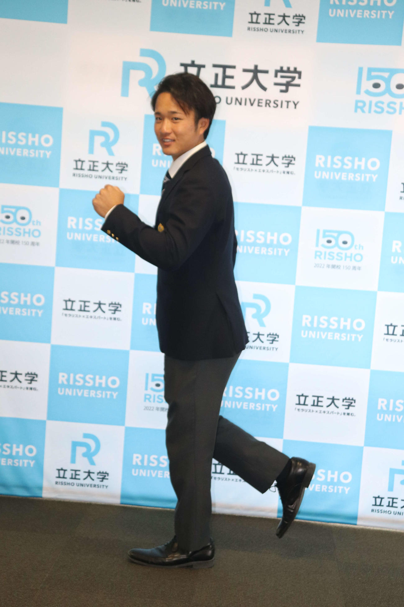 日本ハムと仮契約した5位指名の立正大・奈良間大己は走るポーズをとる（撮影・星夏穂）