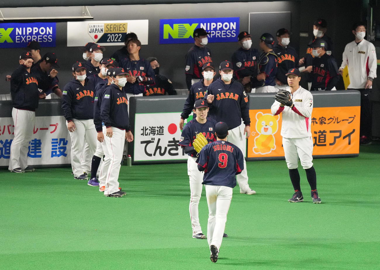 オーストラリア対日本　4回の投球を終えた佐々木朗（中央）は、佐藤輝（右）や村上（中央奥）らナインとともに塩見（手前）を出迎える（撮影・菅敏）