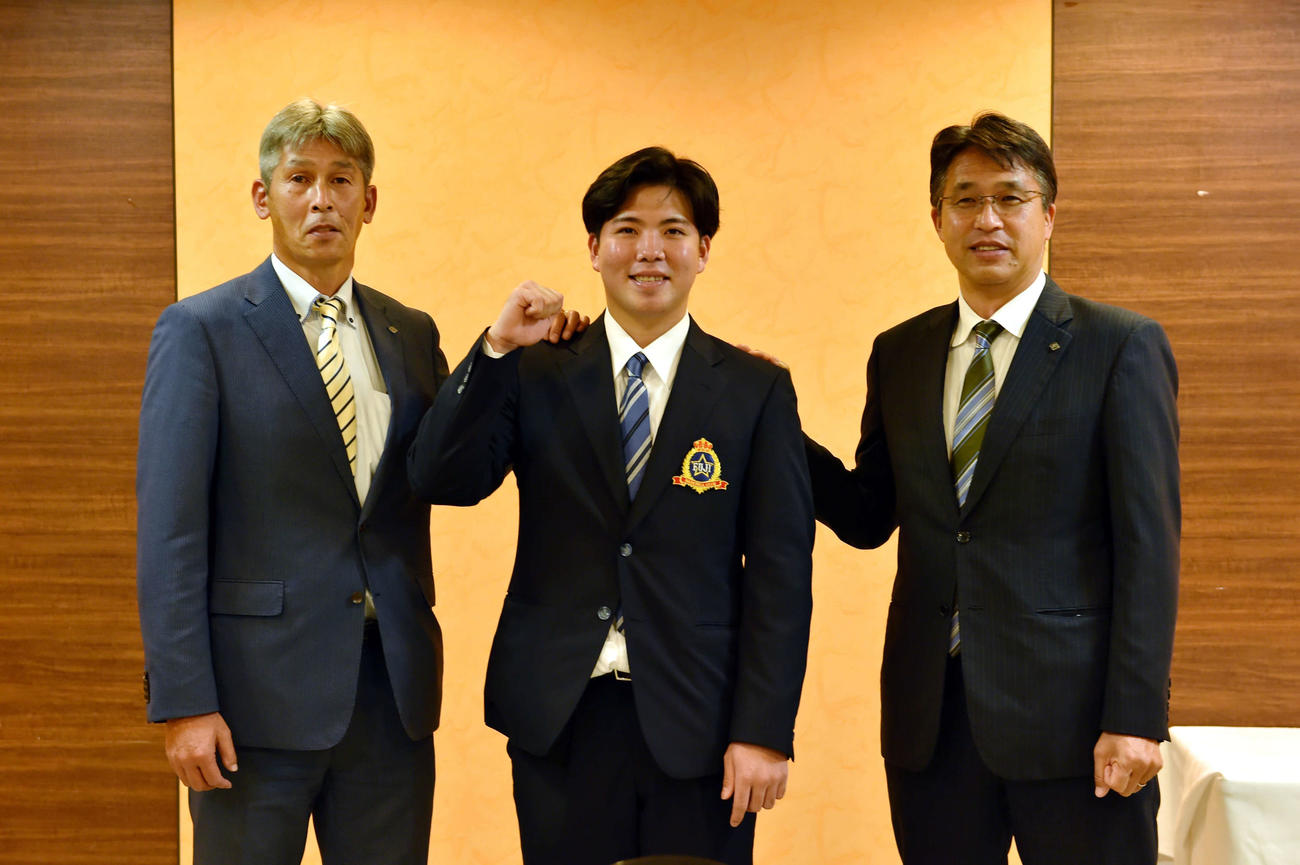 仮契約を終えて笑顔で記念撮影する、左から白井スカウト、金村、大渕GM補佐兼スカウト部長