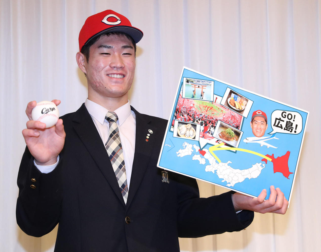 広島ドラフト1位の苫小牧中央・斉藤は仮契約を終え、「GO！広島！」と書かれた手作りボードを手に記念撮影をする（撮影・佐藤翔太）