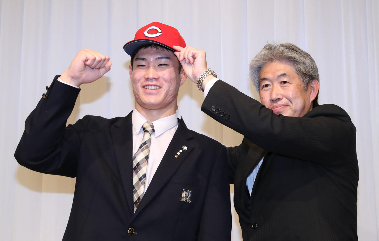 広島ドラフト1位の苫小牧中央・斉藤は仮契約を終え、近藤スカウトと記念撮影をする（撮影・佐藤翔太）