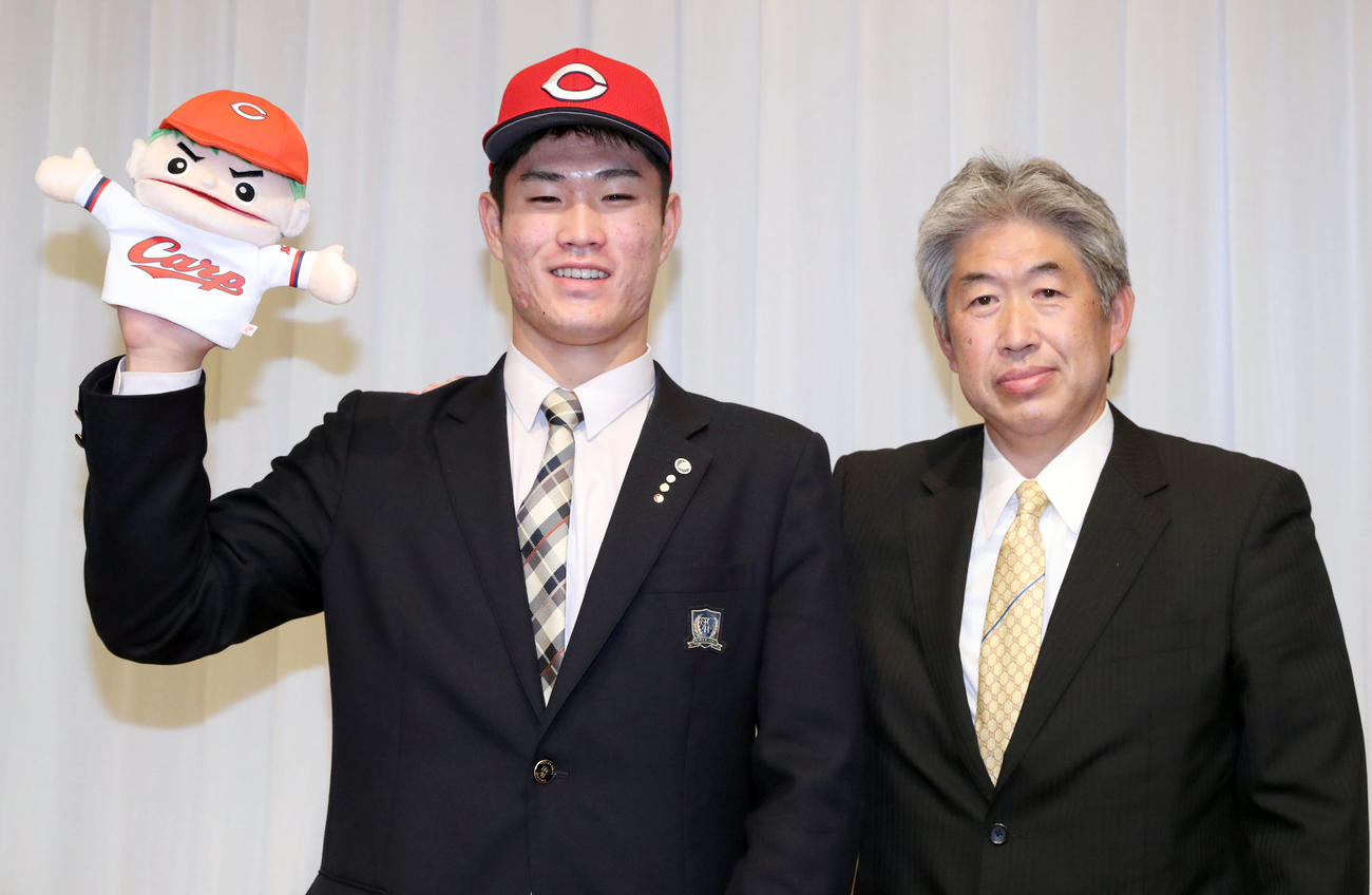 広島ドラフト1位の苫小牧中央・斉藤は仮契約を終え、「カープ坊や」を手に近藤スカウトと記念撮影をする（撮影・佐藤翔太）