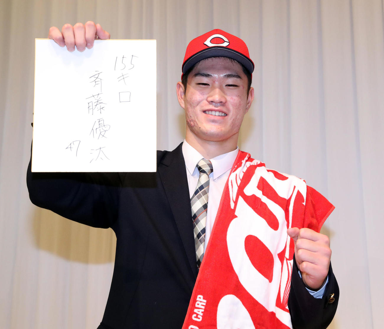 広島ドラフト1位の苫小牧中央・斉藤は仮契約を終え、「155キロ」と背番号47をしたためガッツポーズをする（撮影・佐藤翔太）