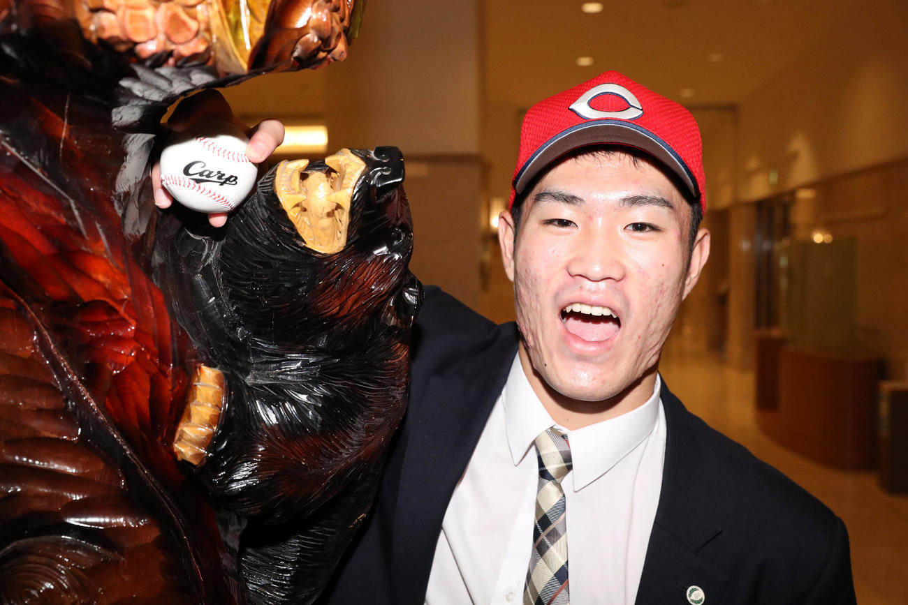 広島ドラフト1位の苫小牧中央・斉藤は仮契約を終え、木彫りの熊と記念撮影をする（撮影・佐藤翔太）