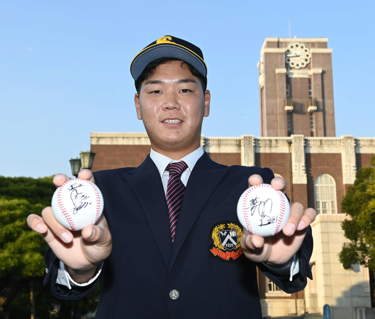 ソフトバンクから指名あいさつを受けた京大・水口はプレゼントされた王球団会長（右手）、藤本監督のサインボールを手に笑顔を見せる（撮影・前岡正明）