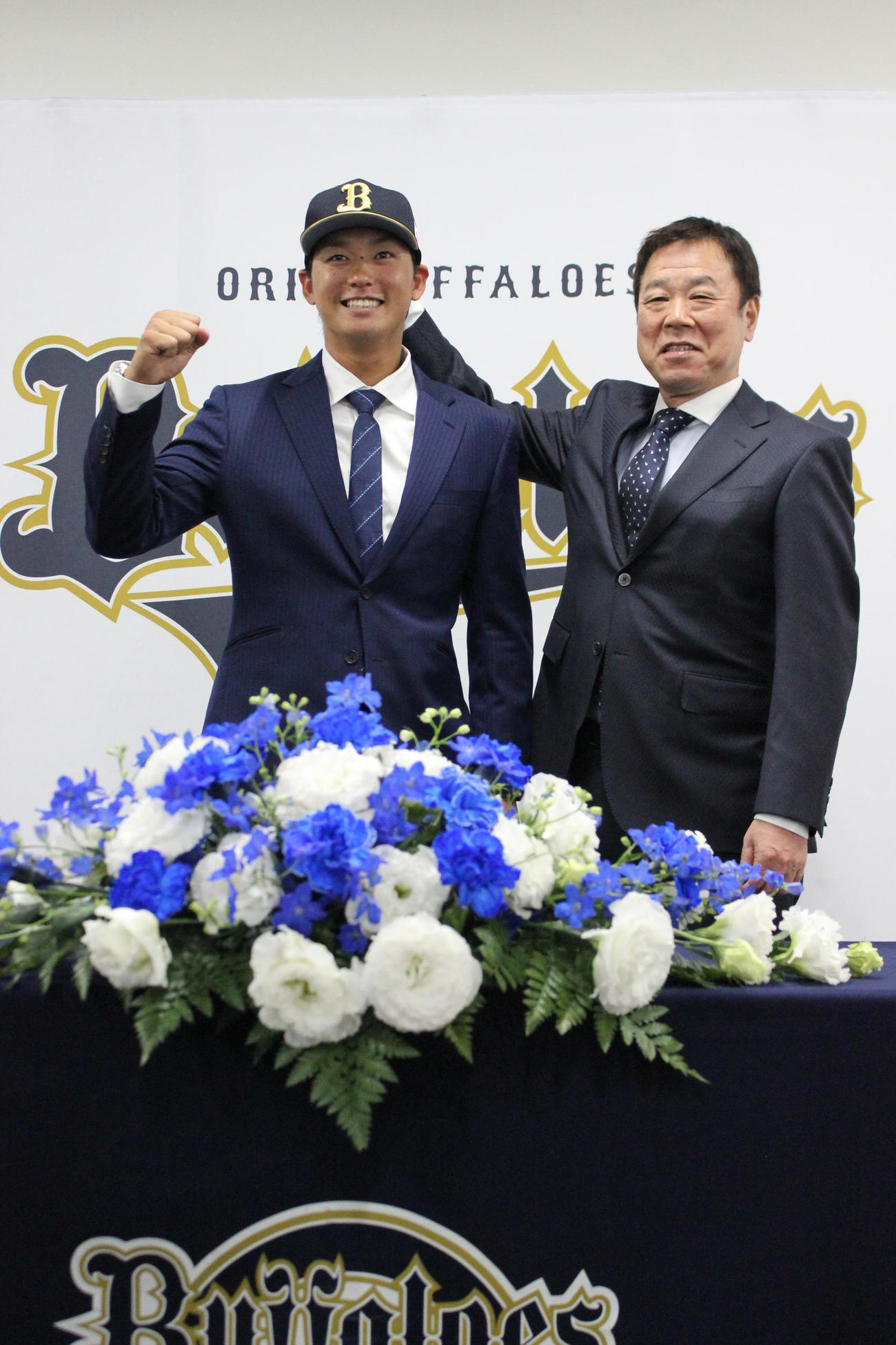 オリックス入団会見で福良GMとポーズをとる石川亮＝2022年11月12日（撮影・柏原誠）