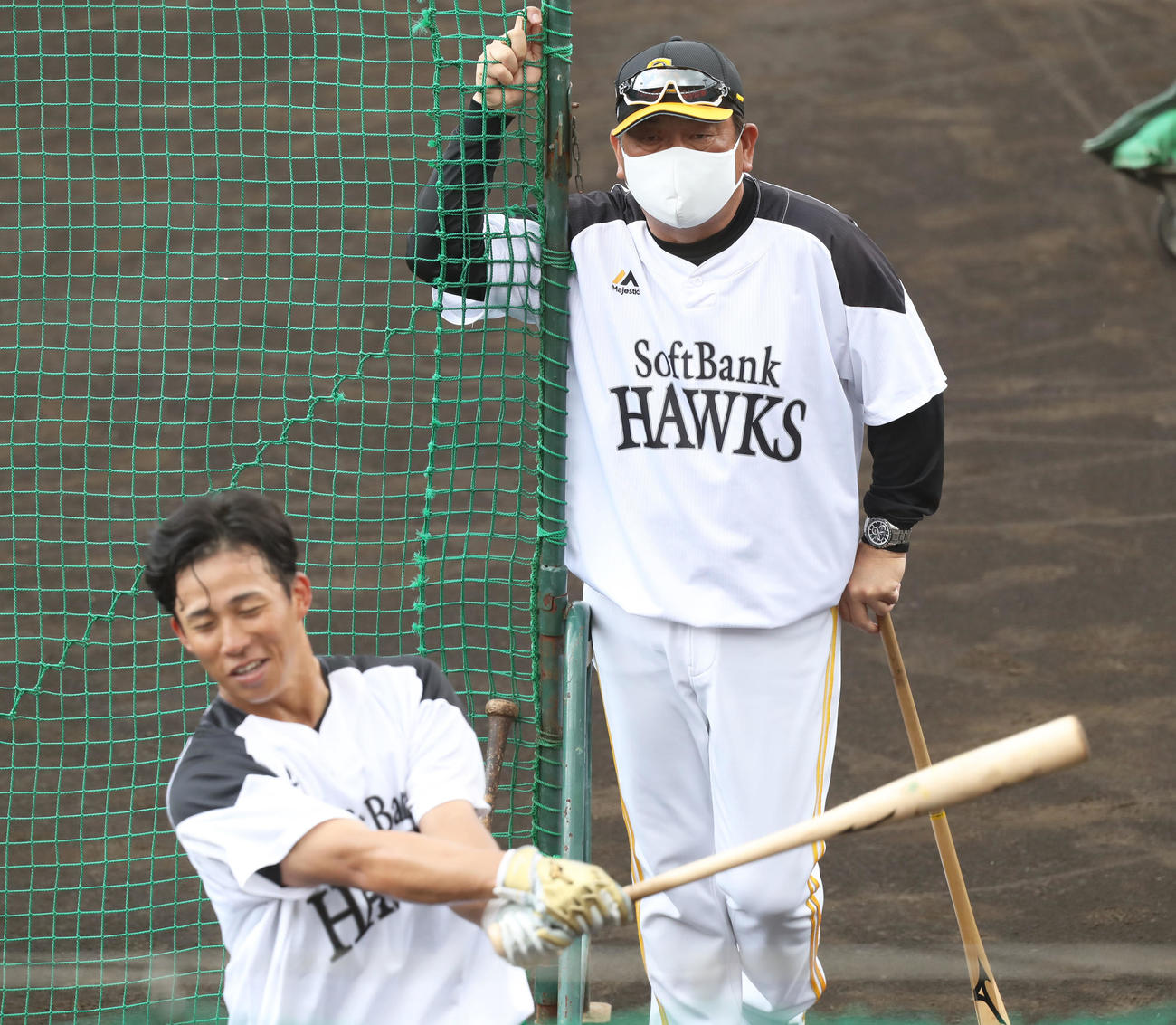 野村勇（手前）のティー打撃を見つめる藤本監督（撮影・屋方直哉）