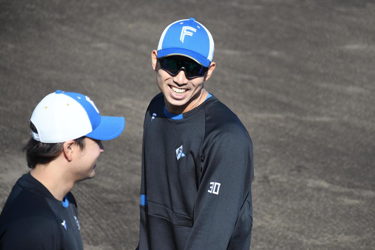 チームメートと会話し笑顔を見せる宇佐見捕手（右）（撮影・石井翔太）